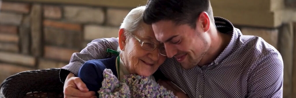 Elderly Lady hugging caregiving man