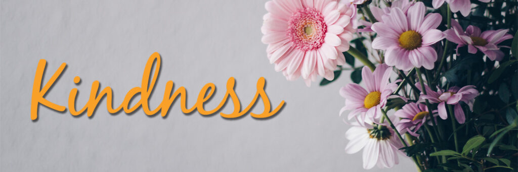 A vase of flowers with a bold word - Kindness