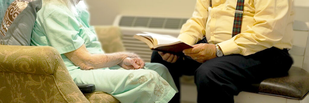 Elderly woman studying scripture with caregiver
